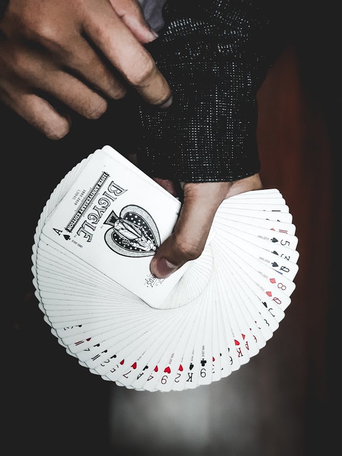 Detailed view of a hand displaying a fan of playing cards indoors, focusing on leisure and card games.